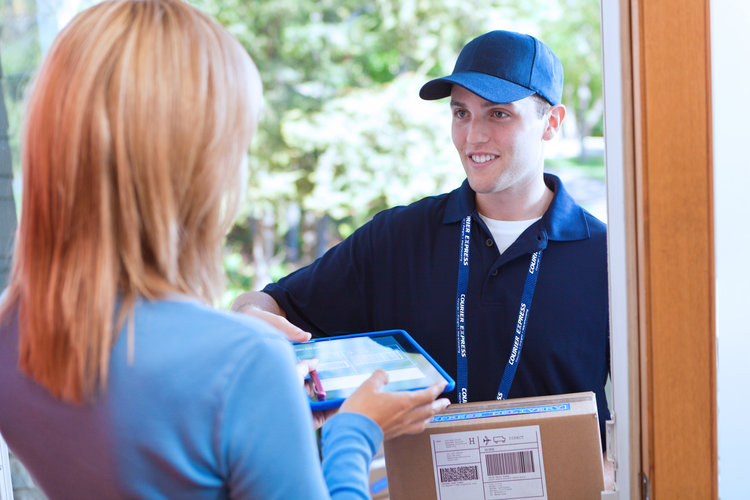 Woman at door accepting delivery from courier