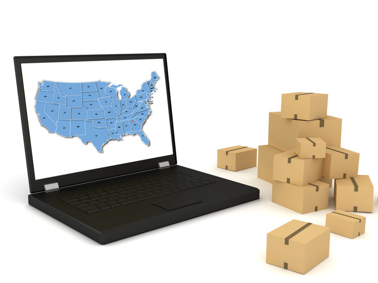 Laptop with the U.S.A. map showing national network of KanjiTrans Services and parcel packages beside it